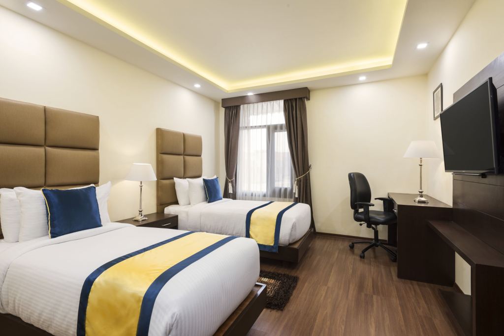 Deluxe Twin Room with two single beds, a work desk and a wall-mounted TV