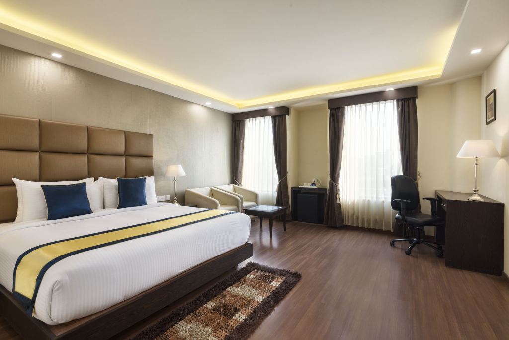 Executive Room with a large bed, two armchairs by the windows and a work desk with an office chair