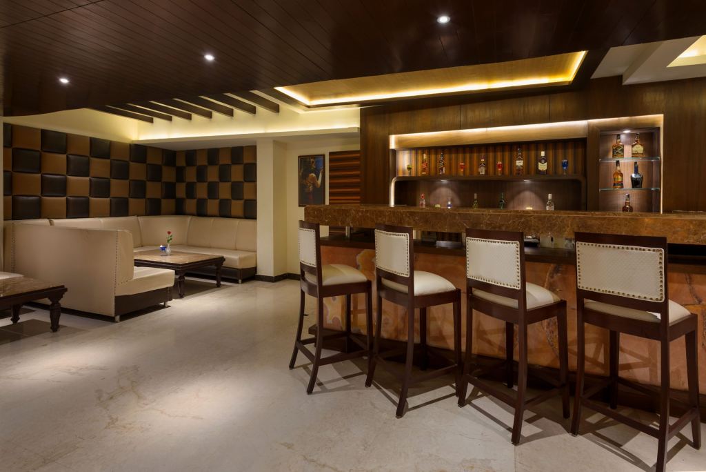 Whisky 21 bar counter with four high stools, a lit back bar of spirits and a sofa booth