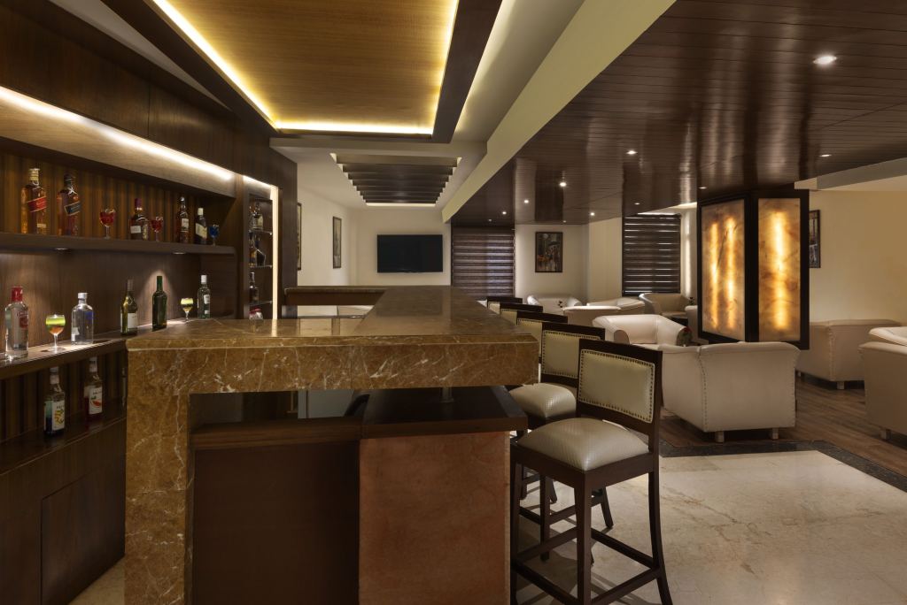 Marble bar counter and stools at Whisky 21, with armchair seating and backlit stone pillars